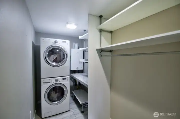 utility room that offers stackable washer/dryer and storage for all your needs.
