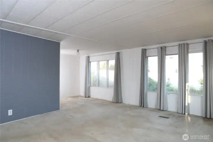 The living room seamlessly flows into the dining area, filled with natural light that creates a warm and inviting atmosphere.