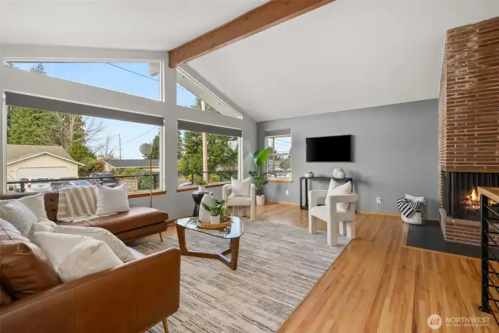 Mid-century style living - refinished original hardwoods, open beams and original angular styled 3-sided fireplace.