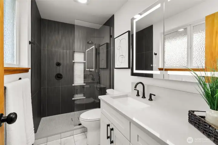 The ultimate spot to get ready for the day! New vanity, tiled floor, chic tiled shower, new fixtures & hardware and that swanky anti-fog LED mirror.