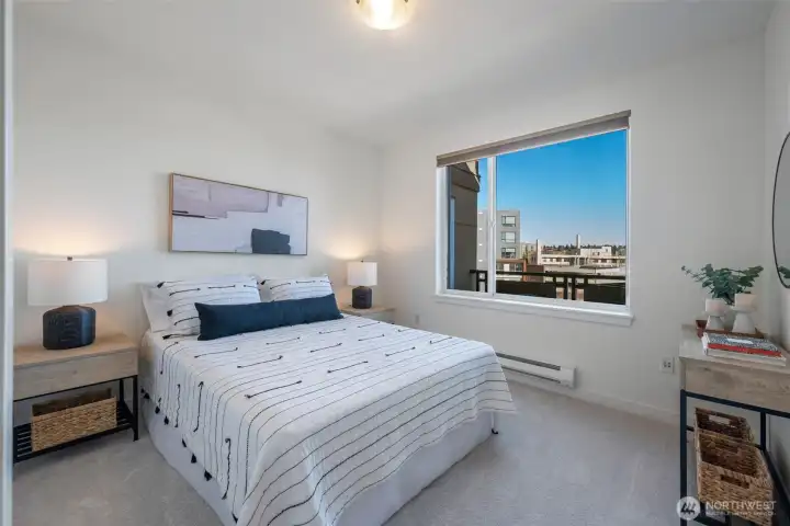 A bright second bedroom sits adjacent to a full bathroom, offering flexibility for guests, work-from-home needs, or creative space.