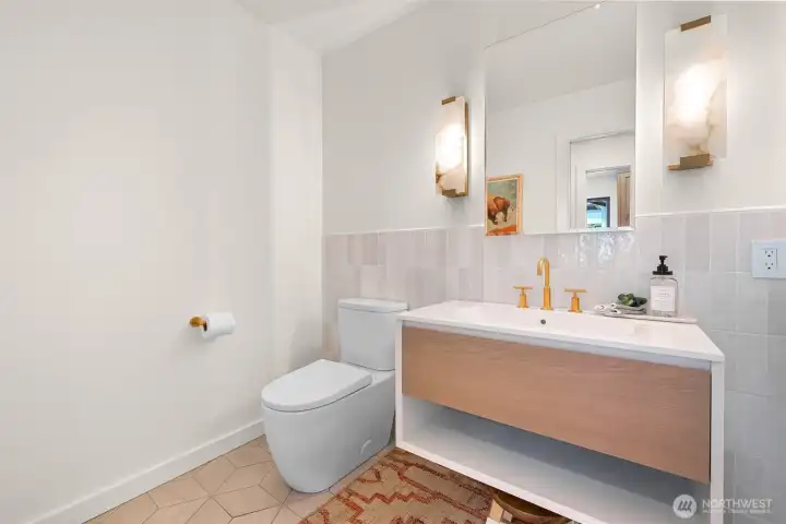 Guests will feel right at home when they visit, thanks to the main floor powder room, where luxury finishes meet thoughtful design. From the welcoming ambiance to the indulgence of heated tile floors, this space is as inviting as it is sophisticated. Every element has been carefully selected to create a warm, polished experience that elevates even the smallest moments of hospitality.