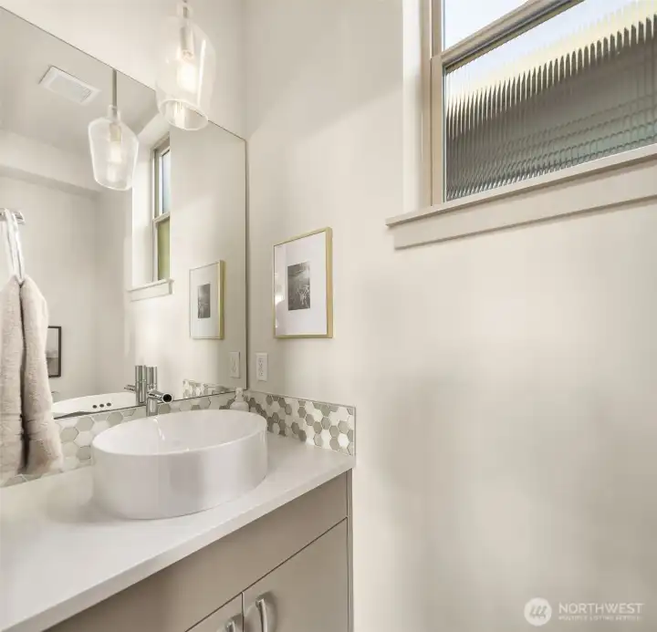 Small space, big style. This chic powder bath pairs a modern vessel sink with designer tile and warm natural light.