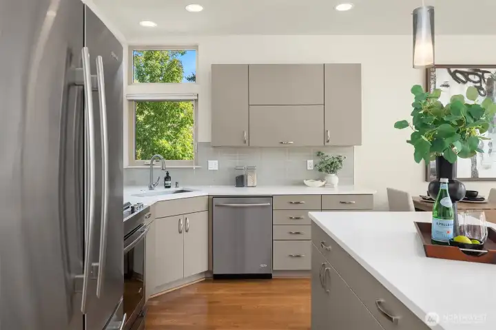 Streamlined cabinetry, quartz counters, and stainless appliances define this functional, modern kitchen.