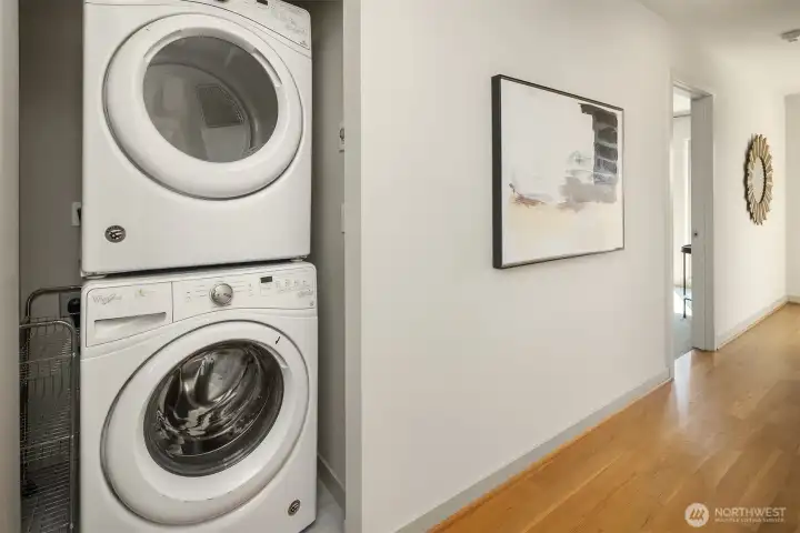 Laundry day, simplified. A sleek stacked washer/dryer is tucked conveniently near the full floor primary suite.