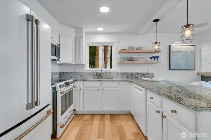 Kitchen is modern and features tons of shaker cabinetry and granite slab counter tops