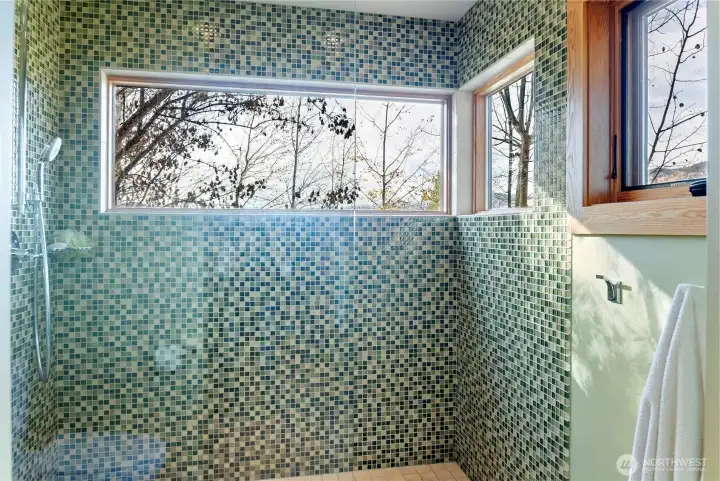 The generous walk-in shower has custom tile work and exceptional views!