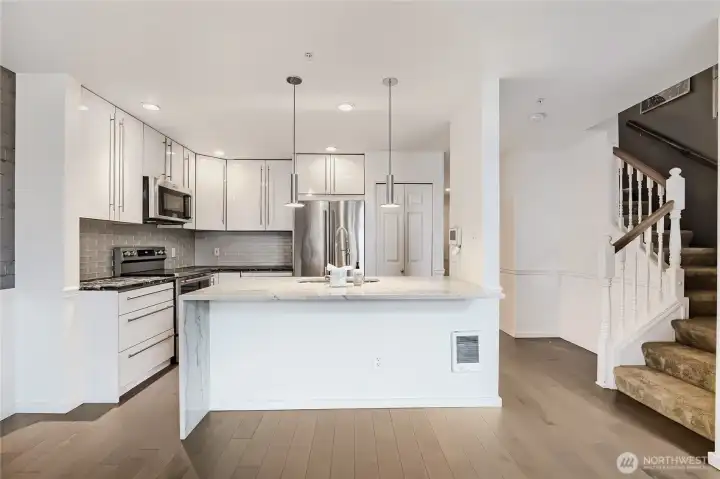 Modern kitchen with white cabinetry and elegant countertops.