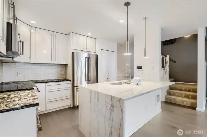 Waterfall-edge peninsula with integrated sink and pendant lighting.