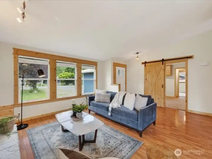 Looking across the living room toward the front entry and the bedroom with the barn door beyond. Looking across the living room toward the front entry and the bedroom with the barn door beyond.