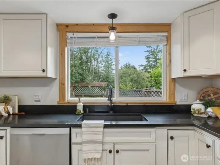 The deep stainless sink looks out to the rear yard and big, back deck. The deep stainless sink looks out to the rear yard and big, back deck.