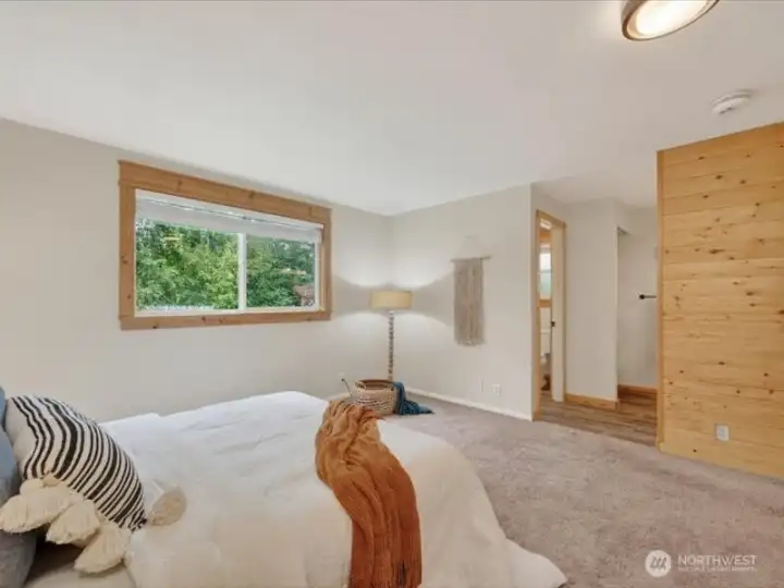 The primary bedroom suite looks to the rear of the home and has a wooden accent wall. The primary bedroom suite looks to the rear of the home and has a wooden accent wall.