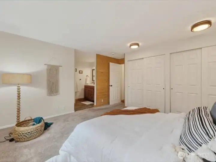 Looking across the primary bedroom with the large closet wall and the 3/4 bath beyond. Looking across the primary bedroom with the large closet wall and the 3/4 bath beyond.