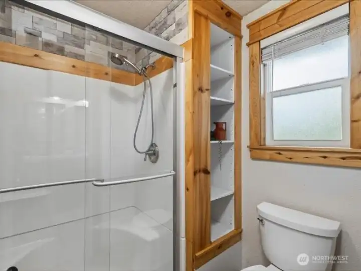 The oversized shower has a glass sliding door and there is linen and toiletries storage, too. The oversized shower has a glass sliding door and there is linen and toiletries storage, too.