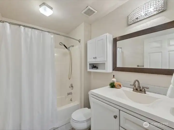 The full bath is between the hall of bedrooms and the dining area. The full bath is between the hall of bedrooms and the dining area.