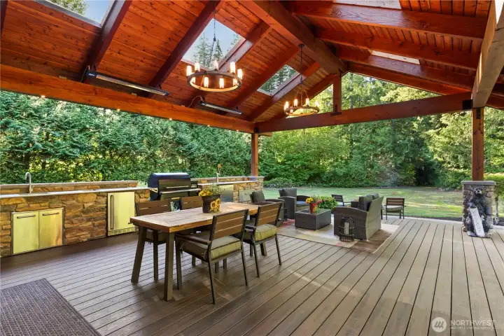 Massive timber frame covered structure with overhead heaters, hot and cold sink, beverage fridge, ice bin, Beer/wine/cider tap, large storage drawers, and electrical and charging outlets.