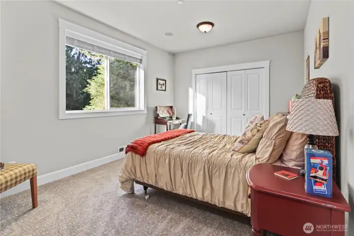 4th bedroom overlooking the lush backyard with connected bathroom.