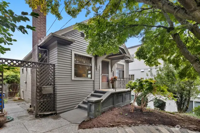 The trellis on the left leads to the fully-fenced backyard.