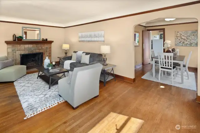 The living room connects to the dining room, with the kitchen beyond in the background.