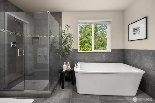 Primary bathroom with soaking tub, seamless glass shower and upgraded shower niche for shampoo.
