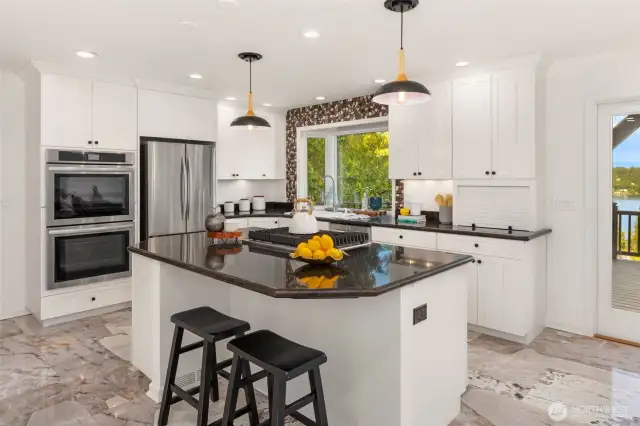 The heart of the home, the kitchen, boasts a gas stove, granite and tile surrounds.