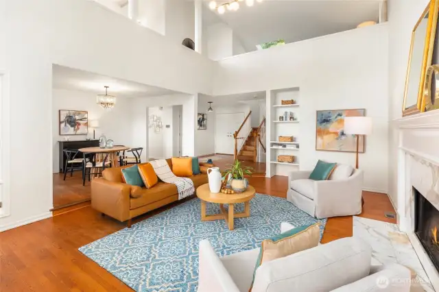 Another view of the elegant living and dining room with lofted sitting rooms and Primary suite above.