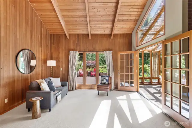 Living room with windows looking to the backyard and French doors to the solarium
