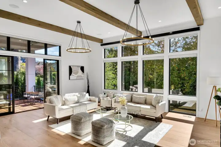 Soaring ceilings and a wall of windows frame the formal living room