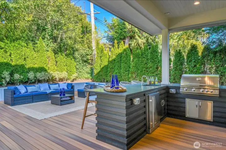 Covered outdoor kitchen with gas BBQ, prep sink and fridge