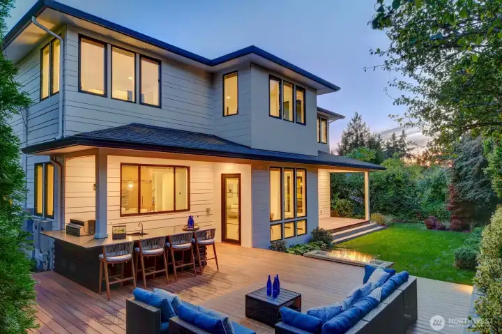 Twilight photo of back deck, gas fireplace and outdoor kitchen