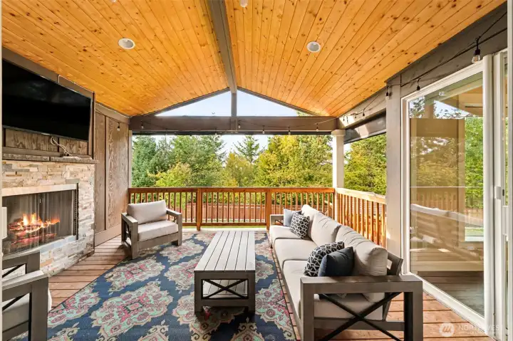 Expanded living space with this covered patio, with fireplace, TV, and remote control shades