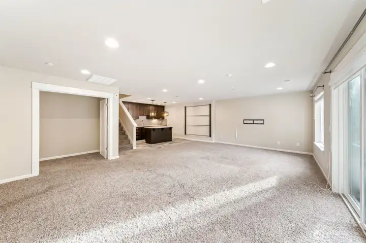 Basement living area, kitchenette and theater/multi-purpose room through the double doors