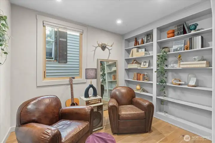 Den/library with custom shelving makes an ideal home office, cozy retreat, or as a 3rd bedroom.