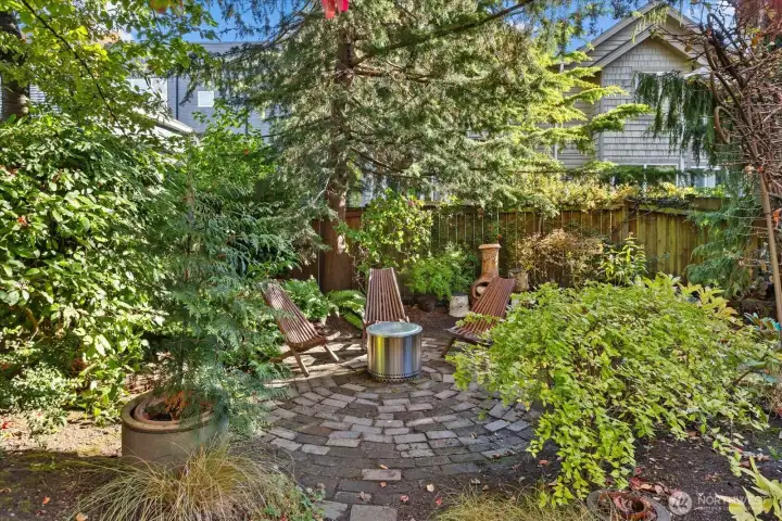 Private garden oasis surrounded by mature native plantings and a serene patio designed for alfresco dining and evening fires.