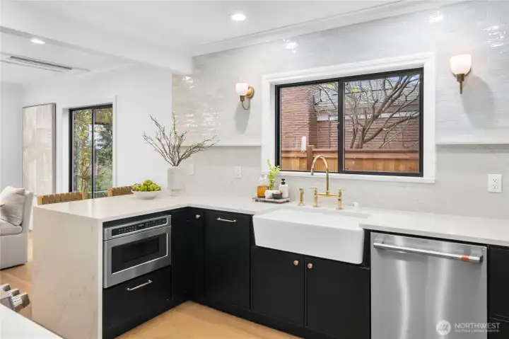 This photo showcases the quartz waterfall island, posh full-height quartz and tile backsplash...