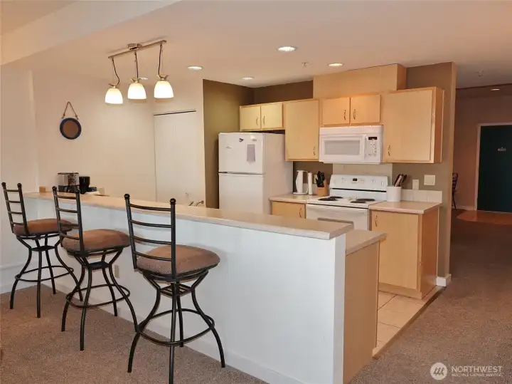 Kitchen has a full-length Eating Bar; tile floors; laminate counters; lots of counter and cabinet space; D/W, Range, Microwave, Refrigerator; and a stackable washer/dryer in the closet.