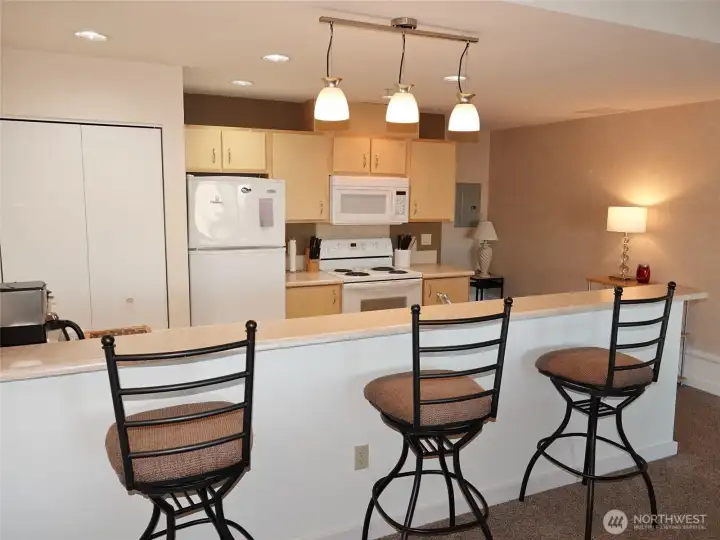 Kitchen has a full-length Eating Bar; tile floors; laminate counters; lots of counter & cabinet space; D/W, Range, Microwave, Refrigerator; and a stackable washer/dryer in the closet.