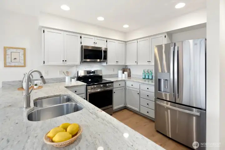 Well appointed kitchen features granite countertops