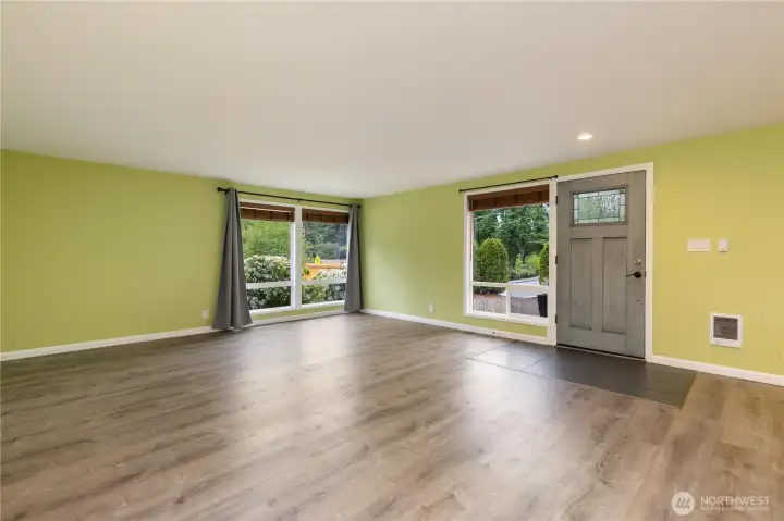 The living room is bright and inviting with large windows on both sides bringing in abundant natural light.