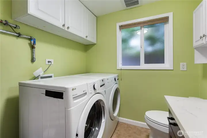 A half bathroom with an installed washer and dryer.