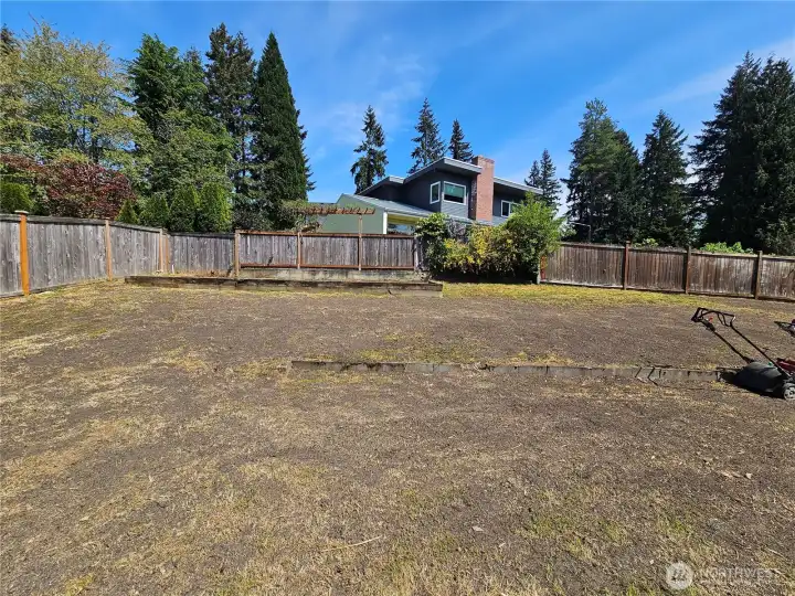 The backyard is currently being freshly landscaped with new lawn installation.