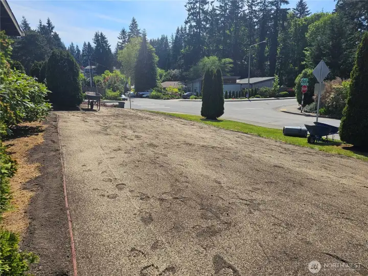 The side yard is currently being freshly landscaped with new lawn installation.