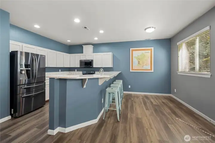 Kitchen features refreshed LVP floors, breakfast bar and eating nook.
