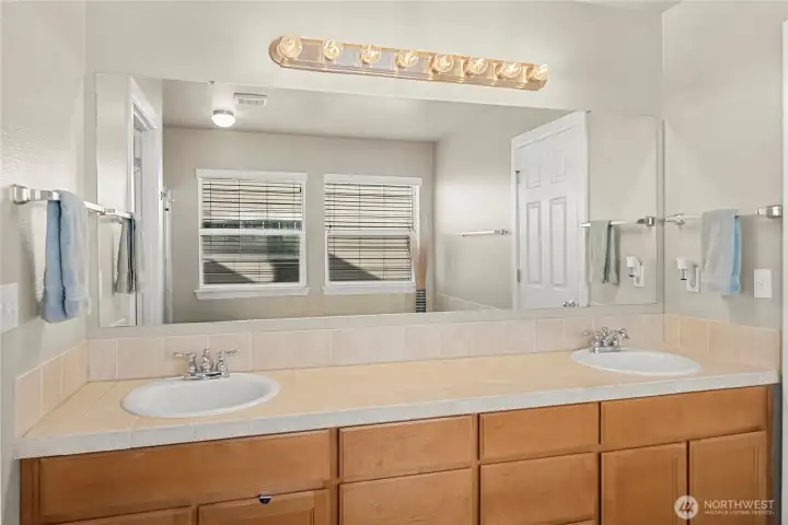 Double sinks and lots of counter and cabinet space in the primary suite bath
