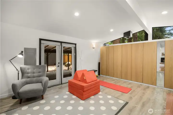 Spacious Family Room with high cathedral ceiling, built-in cabinetry (2020-2021), updated vinyl flooring, and direct access to a covered Back Patio!