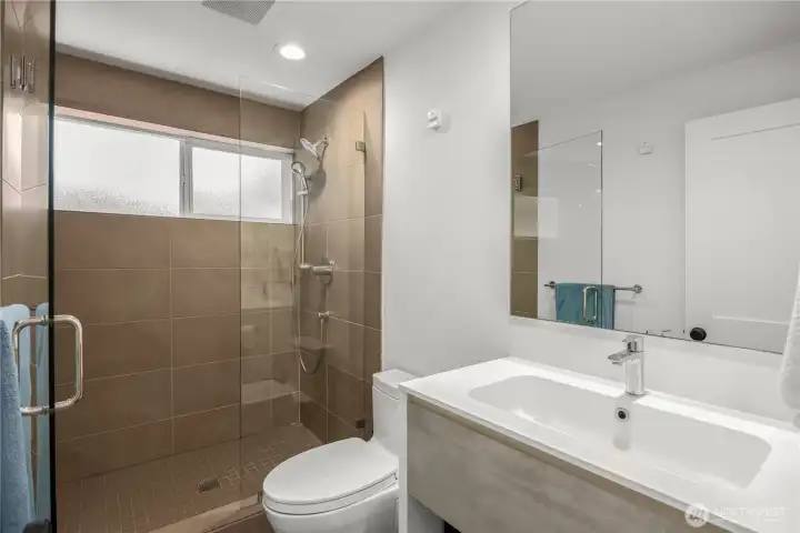 Elegant bathroom featuring a tiled shower, Italian-designed vanity, Toto toilet, and radiant heated floors.