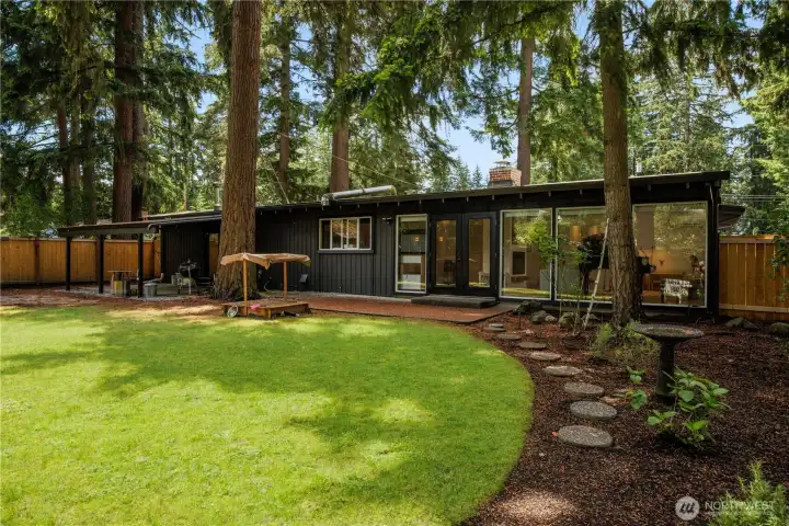 Private, fully fenced backyard featuring a partially covered patio, fire pit, children’s play area, storage shed, and newly updated partial fencing (2025–2026).