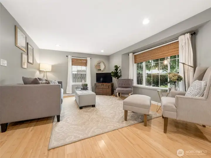 Sunlight pours through the oversized picture windows, making this welcoming living room feel bright, airy, and connected to the beautiful outdoor surroundings.