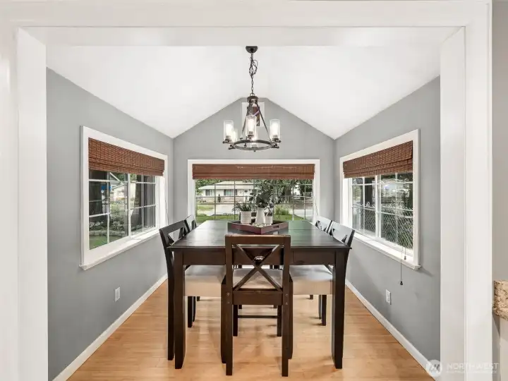 Vaulted ceilings and walls of windows fill this inviting dining room with natural light, creating an airy, elegant space that's perfect for everyday meals or entertaining guests