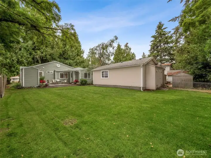 Spacious & private backyard, surrounded by mature plantings. The back of the garage has an attached shed.